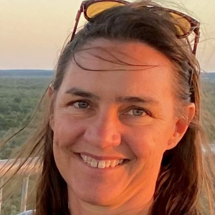 Dr Nathalie Maron smiles at the camera. She has dark hair and is wearing sun glasses on her head.